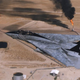 An F-14 Tomcat of VFA-103 “Jolly Rogers” flies over during oil wells during the Gulf War.